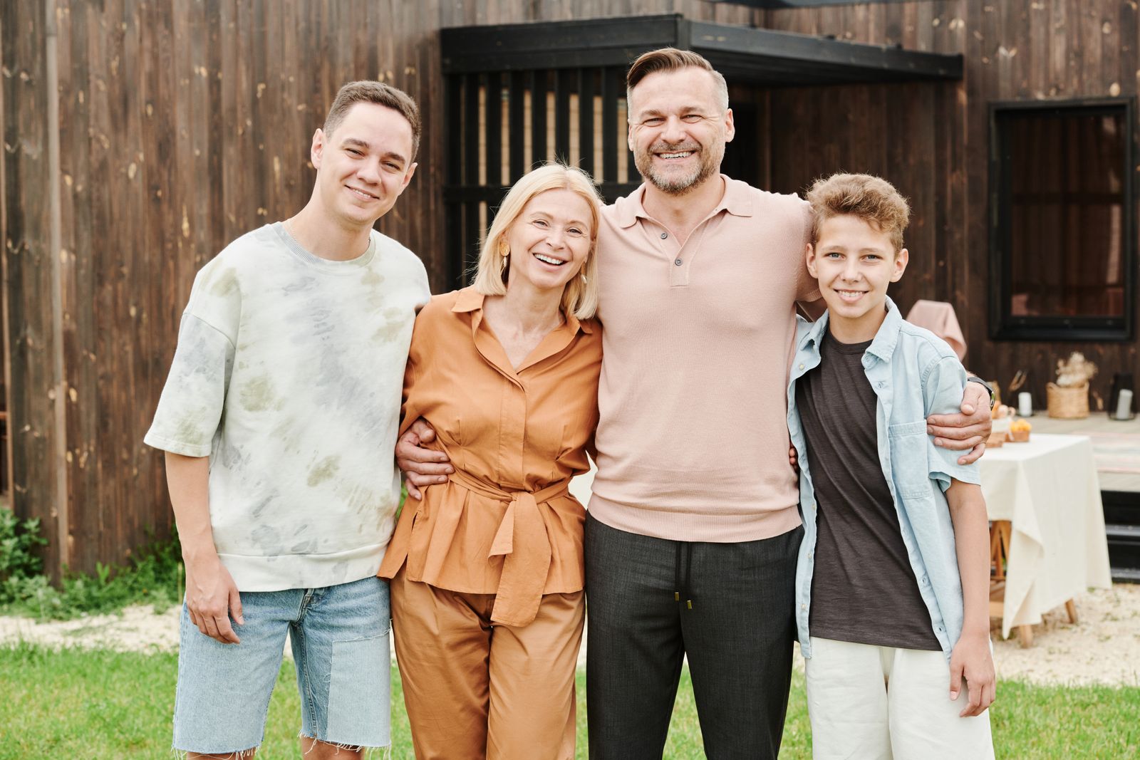 A family of four standing together outdoors, smiling
