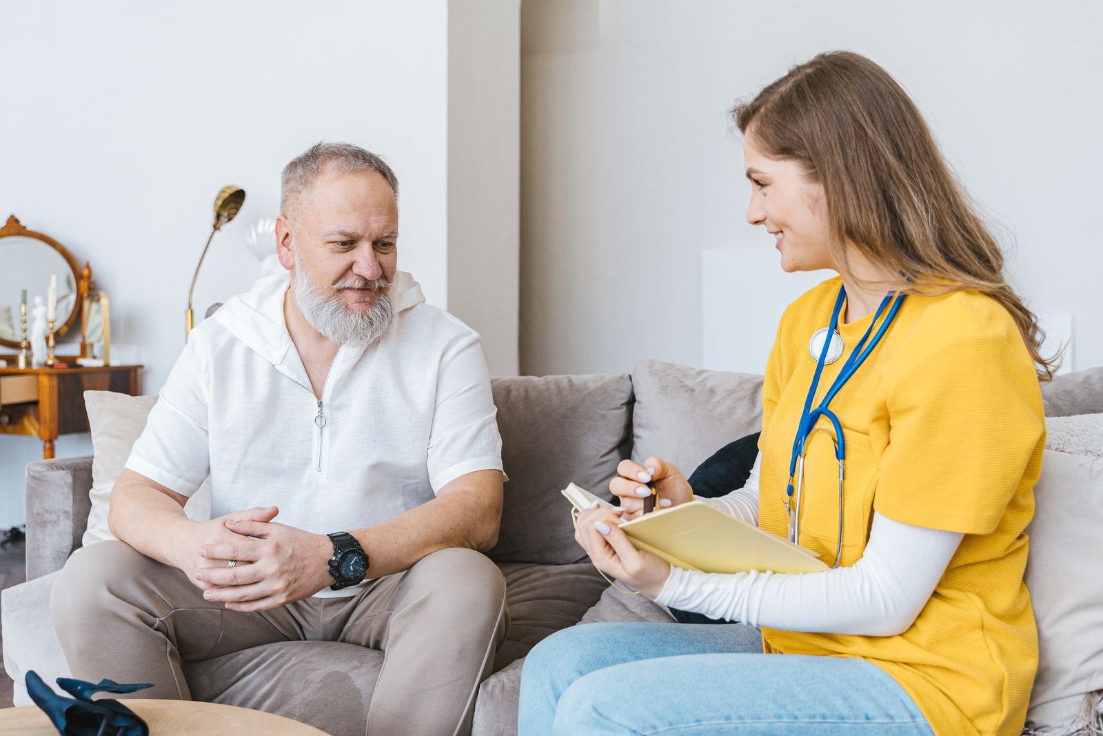 A nurse talking warmly with a senior man at home